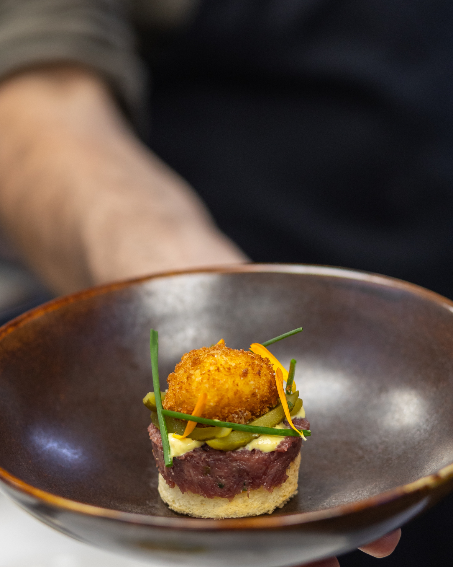 Tartaar de ossenworst, crema de piccadilly, pepinillos agridulces, yema de huevo frita, pan brioche